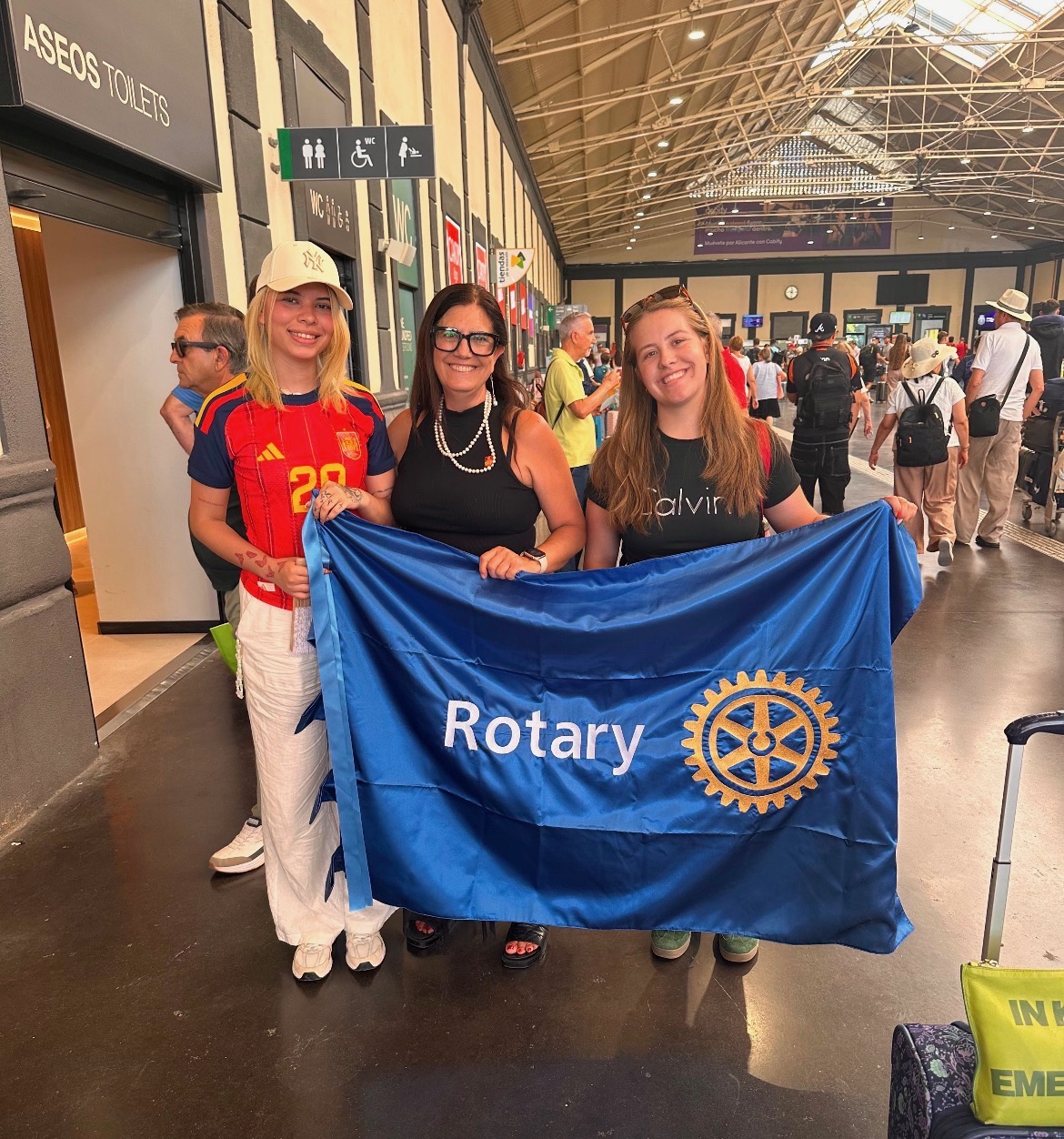 Rotary Youth Exchange students holding a Rotary flag in Spain