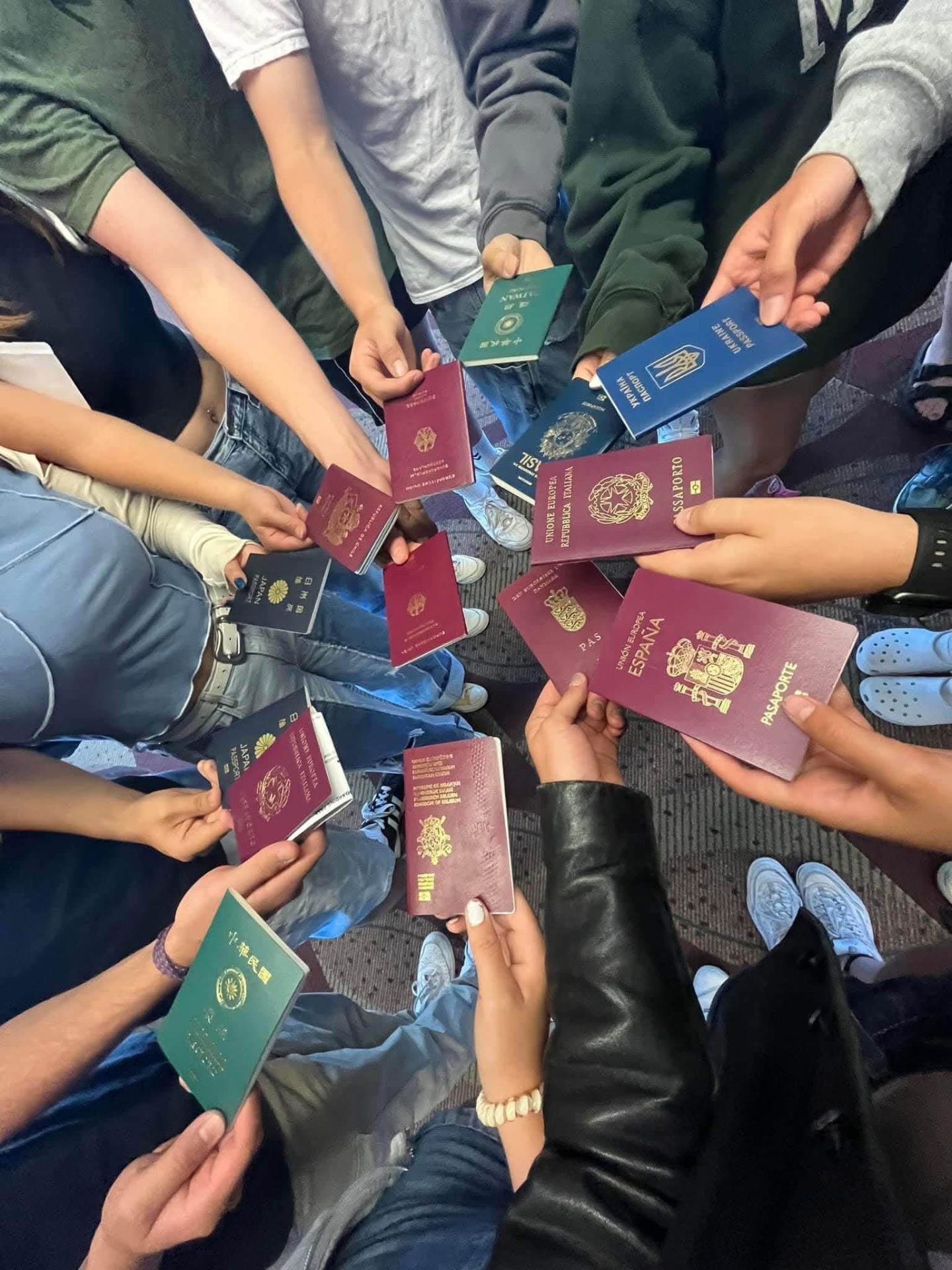 Exchange students holding passports from many countries in a circle